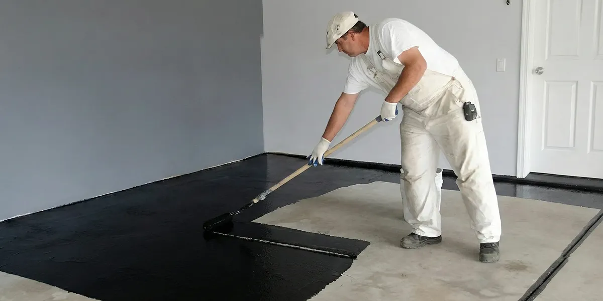 basement waterproofing professional applying waterproof coating to protect a basement floor in Boise, ID